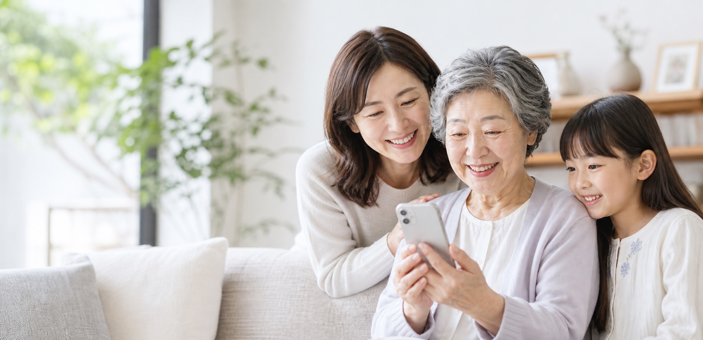 家族がスマートフォンを見ながら笑顔で過ごしている写真